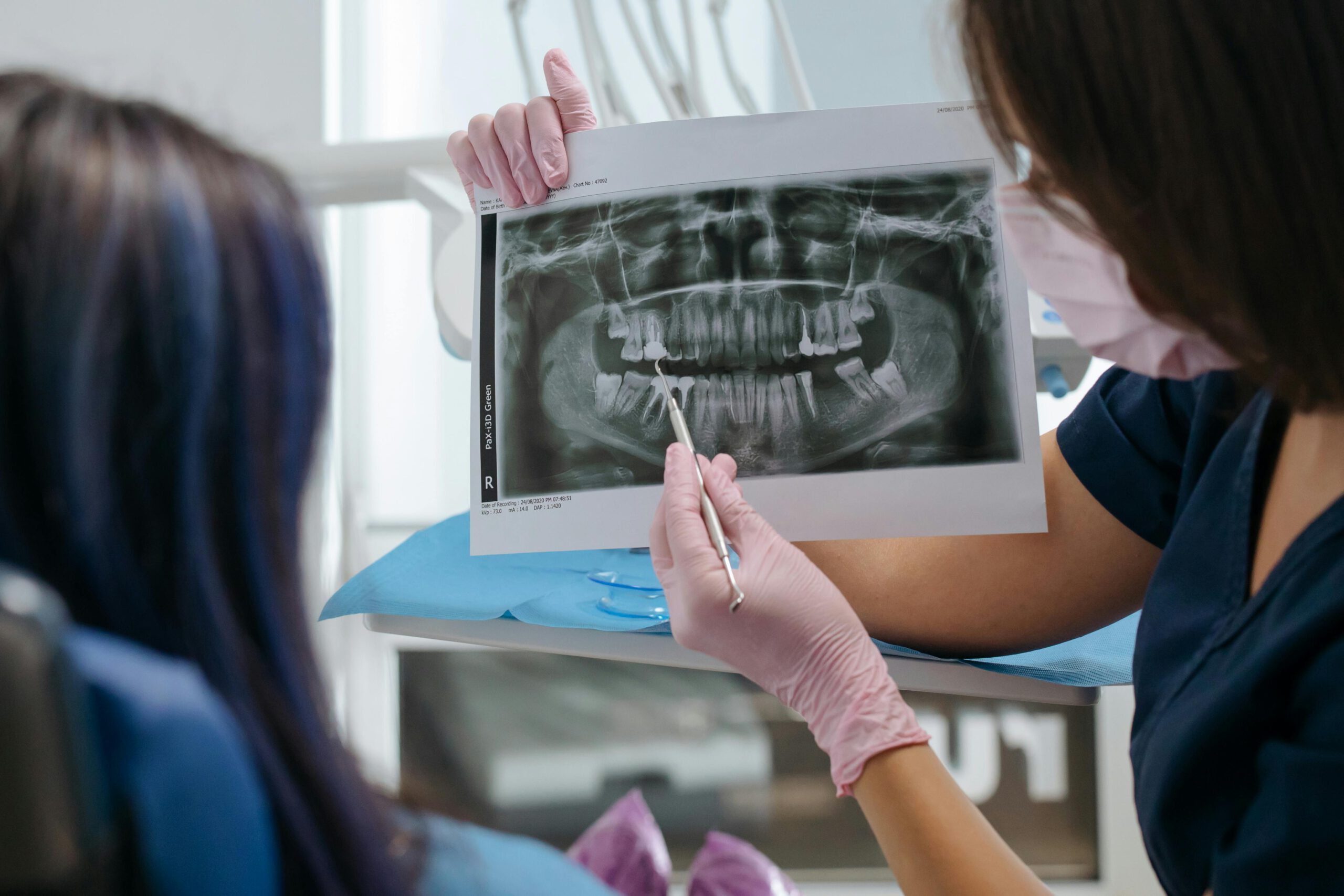 A dentist showing a dental X-ray to a patient, explaining the results and treatment options.
